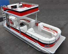 a red and white pontoon sitting on top of a parking lot