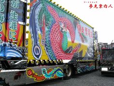 a large semi truck with colorful designs on it's side and trailer behind it