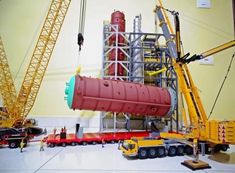 there is a large red object being lifted by a crane in the middle of a room