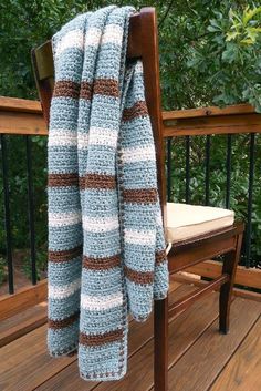 a blue and white blanket sitting on top of a wooden chair