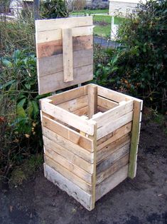 a wooden box sitting in the middle of a yard