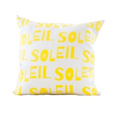 a yellow and white pillow with the words solei printed in bright yellow on it