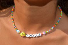 "This dainty necklace is a fun combination of varied, colorful seed beads combined with darling little, emoji smiling faces and the letters spelling smile with hearts.  It is super cute and darling. Lightweight and perfect for a little girl's gift! Clasp is a sterling magnetic clasp (for convenient wear and removal) and findings are all sterling silver. Necklace measures approximately just over 14\" Browse more fun items from my shop here: https://www.etsy.com/shop/uniquebeadingbyme?ref=seller-p Fun Adjustable Necklace With Letter Beads, Fun Adjustable Letter Beads Necklace, Trendy Colorful Beaded Necklaces With Letter Beads, Trendy Colorful Beaded Necklace With Letter Beads, Trendy Birthday Necklace With Letter Beads, Fun Beaded Necklaces With Tiny Beads For Gifts, Fun Beaded Necklace With Tiny Beads For Gift, Trendy Colorful Necklace With Letter Beads, Playful Jewelry With Letter Beads