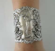 "Art nouveau Bracelet This beautiful silver plated cuff bracelet has a silver plated art nouveau maiden, silver plated chain and lobster clasp. 2.75\" at the widest part. 7\" long adjustable to 9\" long." Victorian Silver Bracelets For Wedding, Victorian Silver Wedding Bracelets, Victorian Hallmarked Silver Cuff Bracelet, Victorian Silver Hallmarked Cuff Bracelet, Antique Silver Cuff Bracelet For Wedding, Victorian Engraved Cuff Bracelet For Gift, Antique Silver Bracelet For Wedding, Antique Silver Wedding Bracelets, Antique Silver Wedding Bracelet