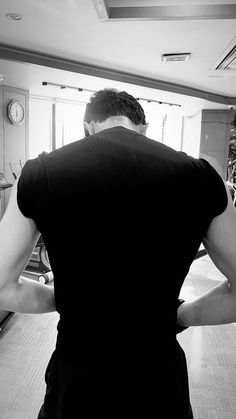 a man standing in front of a kitchen counter with his back turned to the camera