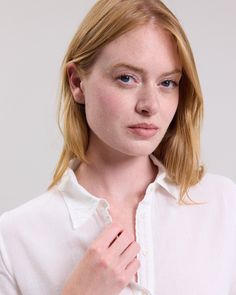 Women's long-sleeved polo tee shirt. Shirt collar and half button placket. Classic White Blouse With Roll-up Sleeves, Timeless Button-up Tops With Placket, Timeless Collared Shirt With Placket, Collared Tops With Button Cuffs, Timeless Long Sleeve Shirt With Placket, White Tops With Roll-up Sleeves For Everyday, Timeless Tops With Fold Down Collar And Placket, Timeless Tops With Placket And Fold-down Collar, Timeless Spring Top With Fold Down Collar