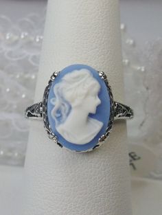 Cameo Ring Edward Design#70 Custom Made Here we have an Edwardian reproduction ring in sterling silver filigree with a variety of resin cameo options, choose from a black, light blue, or light pink lady silhouette, or an deep-orange daisy flower, or a light blue Bell flower. These beautiful cameos measure 14mm in length and 10mm in width. This ring also sits 7mm off the finger. The inside of the band is marked 925 for solid sterling. Notice the beautiful leaf and floral design of the filigree se Edwardian Design, Antique Filigree, Filigree Jewelry, Cameo Ring, Sterling Silver Filigree, Jewelry Antique, Edwardian Fashion, Filigree Ring, Art Deco Art