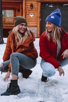 two women sitting in the snow next to each other