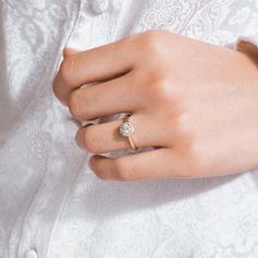 a woman's hand with a diamond ring on her left wrist, wearing a white shirt