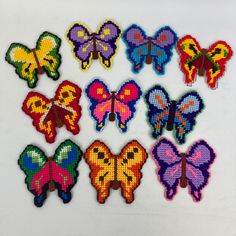 a bunch of different colored butterflies sitting on top of a white table next to each other