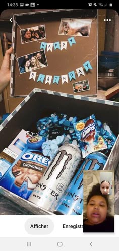 an open box filled with lots of different items next to a woman's face