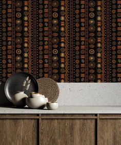 a kitchen counter with plates and bowls on it next to a wallpapered background