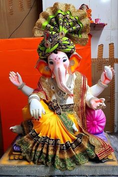 an elephant statue sitting on top of a table next to a red and orange wall