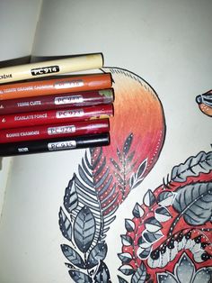 four pencils are sitting on top of a drawing book with an image of a bird