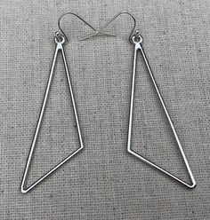 Sleek, modern and cool!  Here are some minimalist statement earrings.  They have a simple modern design and would be perfect for everyday wear.The earrings measure 2 1/8” long by 5/8” wide.  They hang from simple silver ear wire hooks.  Overall drop length is 2 1/4”.  Made from allergy free plated silver.Thanks for stopping by!  Please take a moment and visit the rest of my Etsy shop.  I have many more unique jewelry designs to choose from!🌸 Tiger Flower Jewelry 🌸  🌸 Inspired by Nature 🌸 Modern Geometric Hoop Earrings For Gift, Modern Geometric Hoop Earrings As Gift, Geometric Metal Earrings With Ear Wire, Modern Geometric Metal Hoop Earrings, Minimalist Stainless Steel Drop Earrings, Modern Triangle Metal Earrings, Modern Dangle Plug Earrings, Modern Metal Plug Earrings Nickel Free, Modern Metal Linear Earrings For Everyday Wear