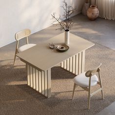 a table with two chairs next to it and a potted plant in the middle