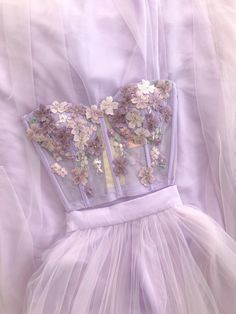 Bustier de tul stretch bordado a mano con flores y cierre de broches que ajusta dos tallasCon copas y varilla Falda de tul fino con forro de charmeuse y pretina de 4 cm Elegant Strapless Spring Bodice, Strapless Fitted Bodice For Spring, Strapless Boned Bodice For Spring, Fitted Lace Bodice With Sheer Detail, Elegant Spring Evening Bodice, Spring Evening Boned Bodice, Summer Evening Corset With Sheer Bodice, Tulle Corset For Prom Party, Strapless Tulle Corset For Prom Season