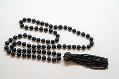 A unique combination of matte round Black Agate beads on the necklace compliments a rich tassel made of 16 strands of tiny black spinel beads. The tassel cap is delicately hand crocheted from oxidized silver wire and more black spinel beads. Black agate Black spinel Oxidized silver MEASUREMENTS Necklace length: 36 inches Tassel: 5 inches You might also like: https://www.etsy.com/listing/231606351/handknotted-aquamarine-necklace?ref=shop_home_active_7 or: https://www.etsy.com/listing/192577724/ha Elegant Hand-strung Beads For Party, Elegant Black Tassel Necklace, Elegant Jewelry With Tassels And Round Beads, Elegant Round Beaded Tassel Jewelry, Elegant Hand-strung Onyx Necklaces, Elegant Onyx Hand-strung Necklaces, Elegant Hand-strung Onyx Necklace, Elegant Onyx Hand-strung Necklace, Elegant Hand-strung Beaded Necklaces For Party