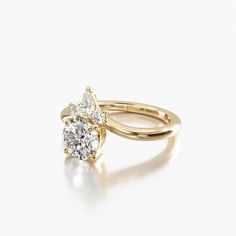 a rose gold engagement ring with two pear shaped diamonds on the top and bottom, set against a plain white background