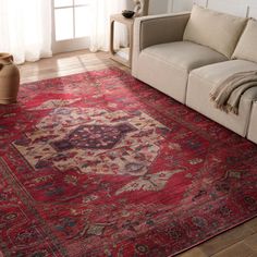 a living room area with a couch, rug and window