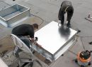 two men are working on an aluminum table