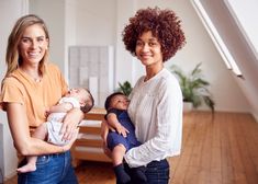 two women and a baby are standing in the living room with an open floor plan