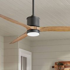 a ceiling fan in a room with white walls and wood trimmings on the ceiling