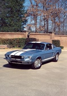 an old mustang sitting in a parking lot