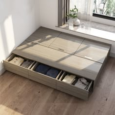 an open drawer on the floor in front of a window