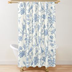 a blue and white floral shower curtain hanging on a bathroom wall next to a bathtub