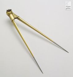 two pairs of gold colored scissors on a white surface with clippings attached to them