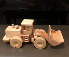 a wooden toy tractor and plow on a table