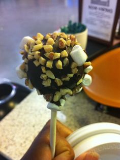 a person is holding a candy lollipop with marshmallows on it