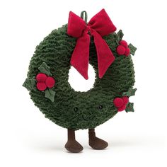 a green wreath with red berries and a bow on it's head is standing in front of a white background