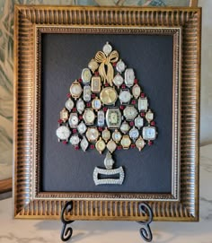 a christmas tree made out of old watch parts is displayed in a gold framed frame