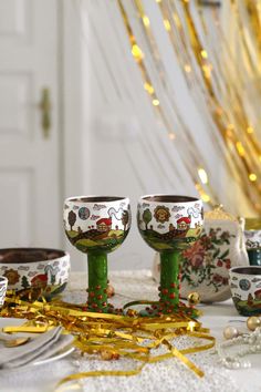 three wine goblets sitting on top of a table next to confetti