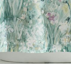 an abstract painting with flowers and leaves on the back of a bathtub cover in front of a window