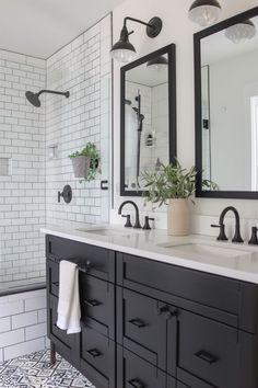 a black and white bathroom with two mirrors on the wall, double sinks, and tiled walls