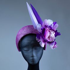 This stunning purple halo headband fascinator is the perfect finishing touch for any occasion. Handcrafted from high-quality materials, it features a purple sinamay base, delicately adorned with feathers, flowers, and a beautiful pearl and crystal centerpiece. The band is covered in a soft, comfortable fabric to ensure a secure and comfortable fit for all-day wear. Whether you're attending a wedding, a day at the races, or a special event, this headband fascinator is sure to turn heads and add a Purple Headband With Handmade Flowers, Purple Handmade Flowers Headband, Spring Party Purple Headband, Purple Handmade Flowers Fascinator For Party, Purple Fascinator With Handmade Flowers For Parties, Purple Party Fascinator With Handmade Flowers, Purple Headpieces For Spring Races, Elegant Purple Headband For Spring, Spring Purple Headband