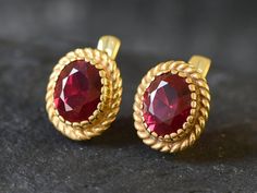 Gold Ruby Earrings set with a Created Ruby in a flawless diamond cut at 10x8mm (6 Cts a pair).Gold Vermeil: 18k Gold over Solid 925 Sterling Silver ☞ made to last.Click here for ☞ Matching RingClick here for ☞ Matching PendantDetails:• Created Ruby in a flawless clarity• Ruby: 10x8mm, 6 Ct a pair, diamond cut• Lever Back Closure - "English Lock"• Length 15mm, Width 12mm• 18k Gold VermeilSKU 2350 Ruby Sets Indian Gold, Oval Gemstone Clip-on Earrings For Gifts, Gold Ruby Earrings, Couple Rings Gold, Ruby Earring, Gold Kada, Simple Gold Earrings, Vintage Gold Earrings, Ruby Earrings Studs