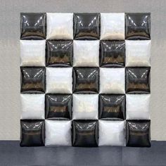 a black and white checkerboard wall with pillows on it