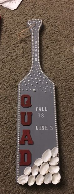 there is a bottle shaped sign on the floor with white pebbles in it that says gud