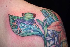 a frog sitting on top of a leaf with lily flowers around its neck and back