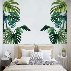 a bed sitting under a palm leaf wall mural