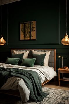 a bed with green pillows and blankets in a dark colored room, next to two hanging lights