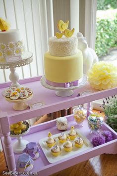 a table topped with lots of cakes and cupcakes