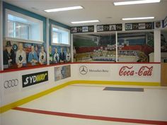 an indoor ice rink with coca - cola advertisements on the wall and windows above it