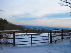 a wooden fence with snow on the ground