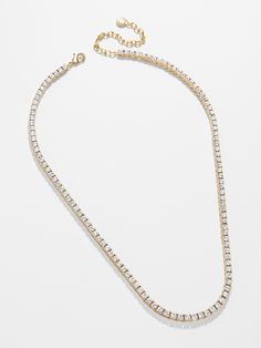 Ace every occasion in the Bennett 18K Gold Tennis Necklace. This classic piece features luxe 18K gold plated sterling silver and Cubic Zirconia Stones. It's bound to be a staple accessory that you'll never take off. Note that clasp should be worn on the right side of neck. Formal Fine Jewelry Necklaces With Bling, Gold Necklaces With Sparkling Stones, Formal Bling Fine Jewelry Necklaces, Dazzling Gold Jewelry With Sparkling Stones, Classic Gold Necklace With Sparkling Stones, Luxury Gold Diamond Necklace With Sparkling Stones, Gold Crystal Necklace Fine Jewelry, Elegant Gold Diamond Necklace With Sparkling Stones, Formal Gold Diamond Necklace With Sparkling Stones