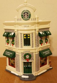 a starbucks coffee shop with green awnings on the front and white brick building